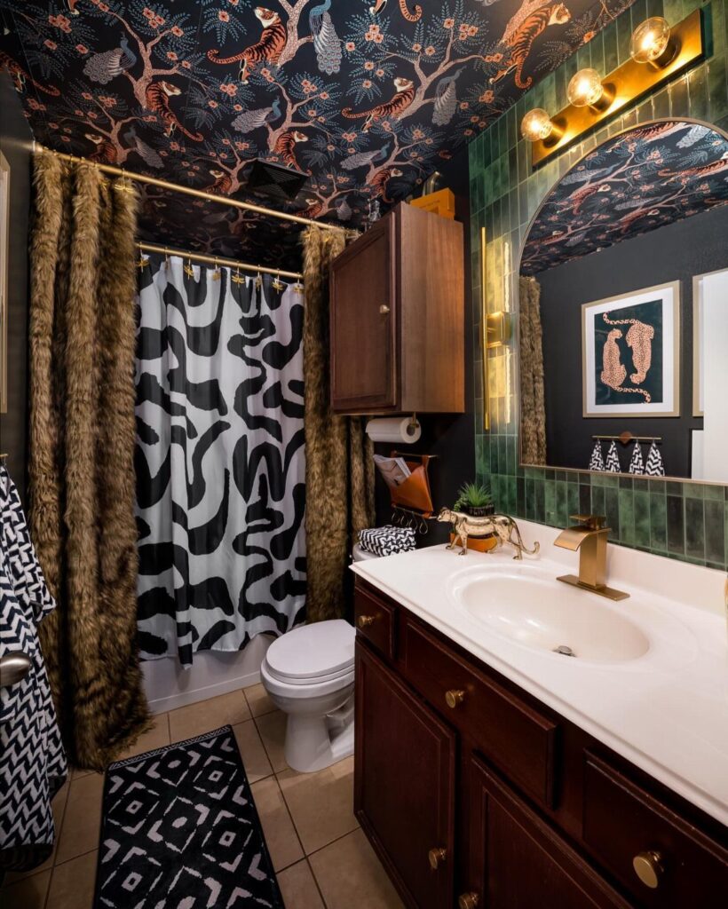 Bathroom with dark blue animal print wallpaper on the ceiling and white sink.