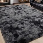 Grey and black shag rug on a light wood floor in a living room.