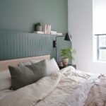 Bedroom with sage green walls and matching linens creating a calm atmosphere.