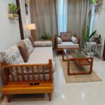 Wooden sofa and armchair with a glass coffee table in a small room