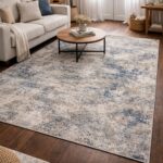 Blue and beige distressed area rug in a modern living room with white sofa