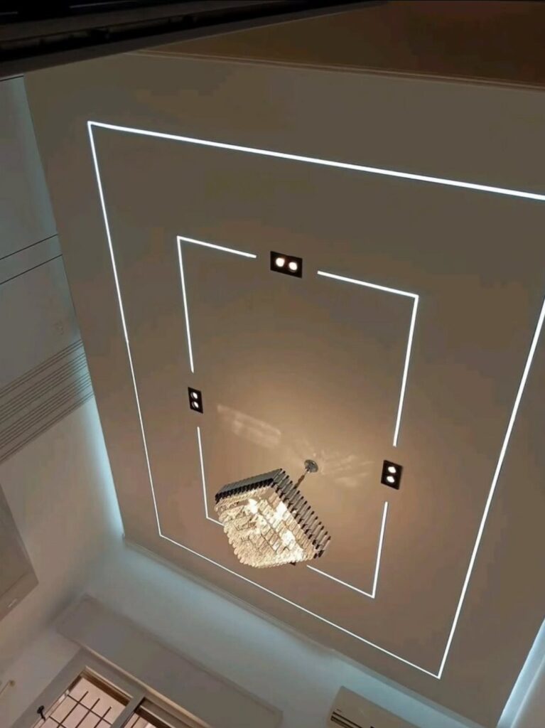 Modern white ceiling with rectangular recessed light strips and a crystal chandelier.