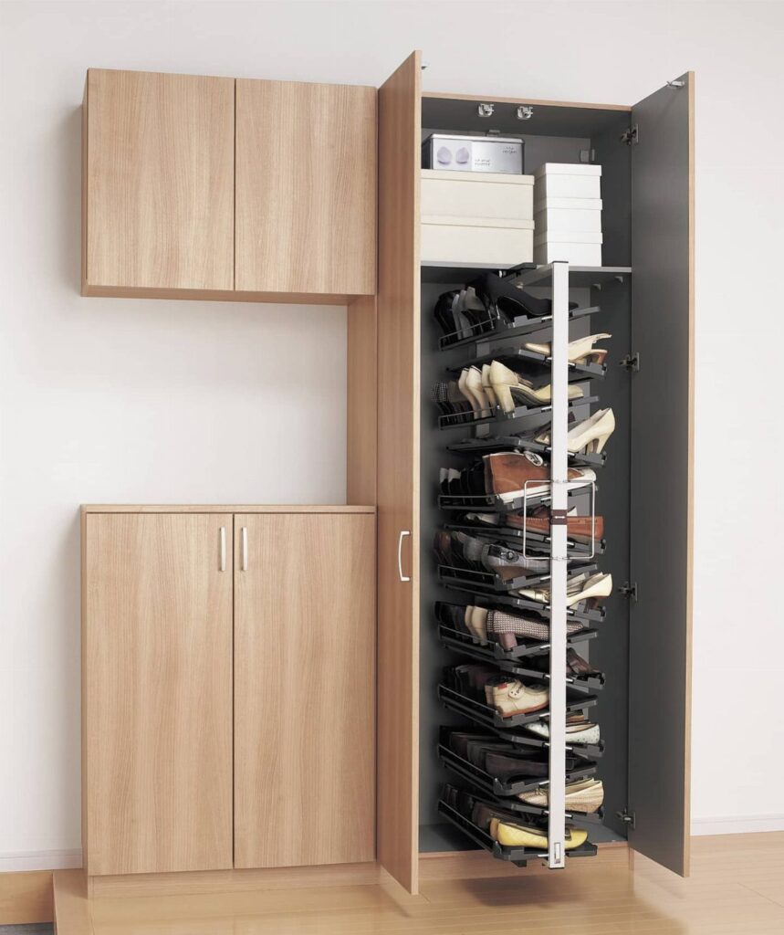 Pull-out vertical shoe rack inside a light wood cabinet filled with various women's shoes.